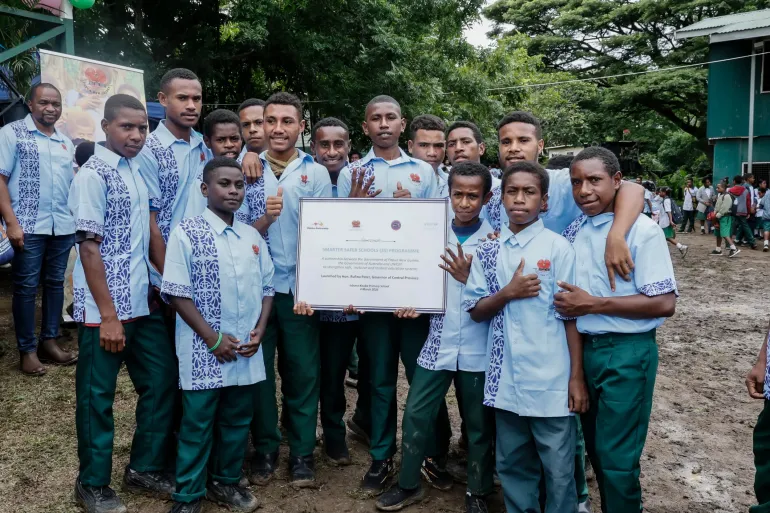 Students of Iobuna Kouba Primary School pose with the 3S Launch Plaque