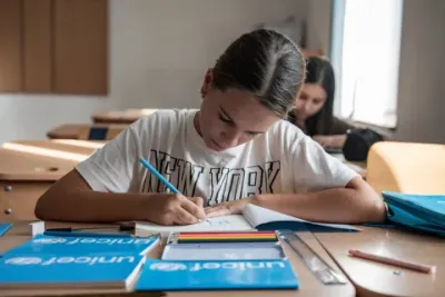 Adolescentă care scrie pe caiet.