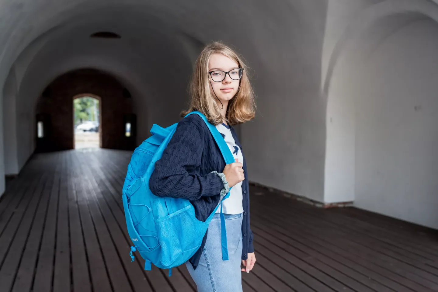 Poză cu o adolescentă cu un ghiozdan &icirc;n spate.