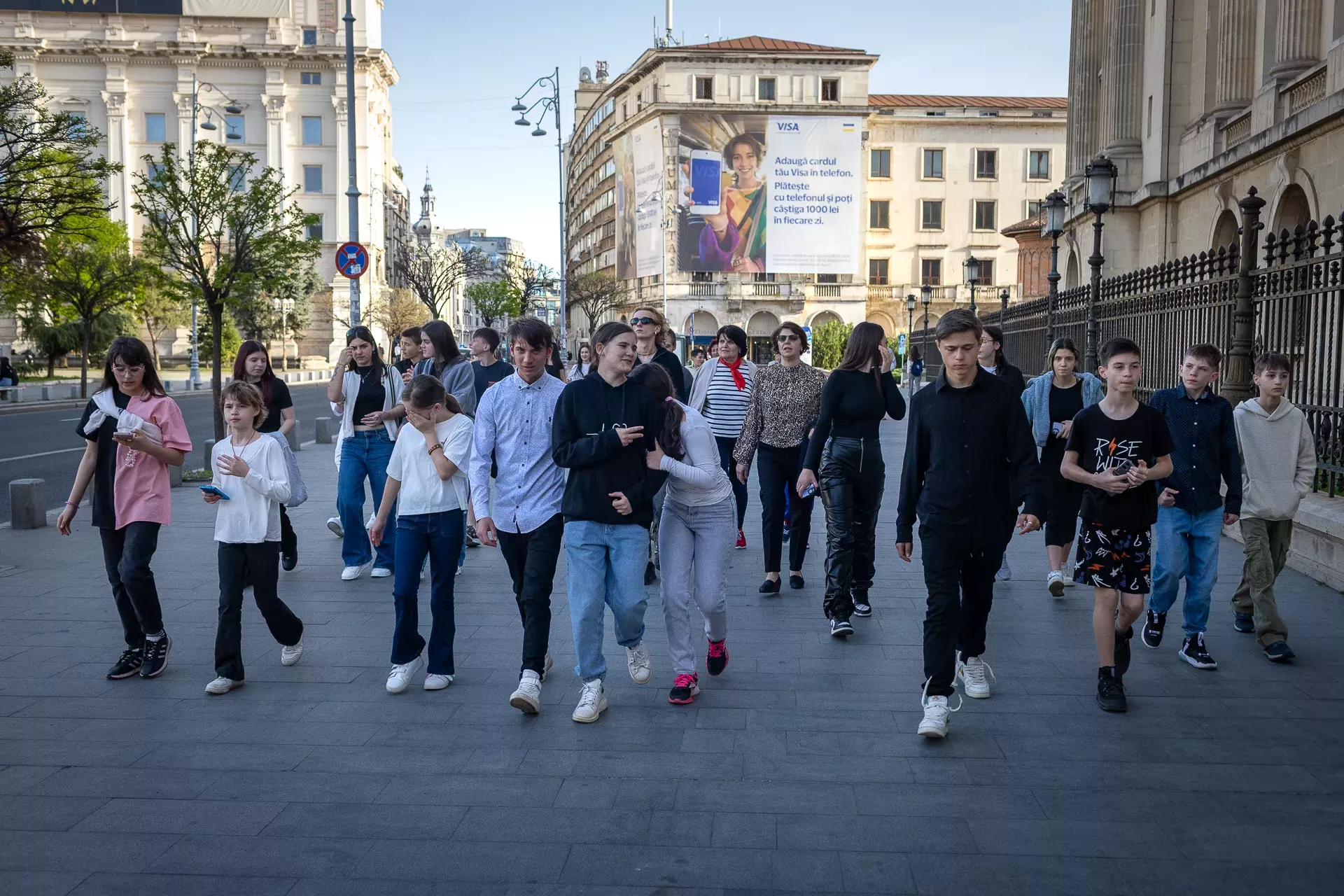 Grup de copii merg&acirc;nd &icirc;mpreună pe stradă. 