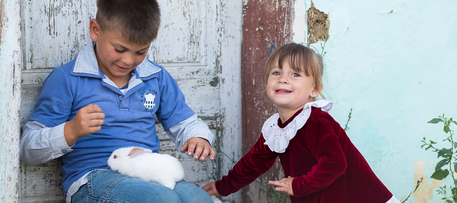 Boy and a girl playing with a rabbit