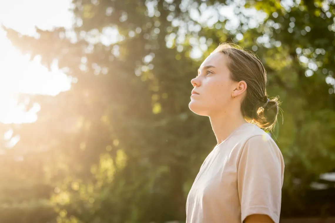 Side profile of an adolescent girl looking into the horizon.