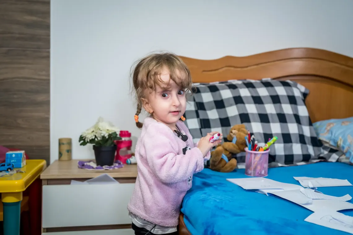 A girl coloring on a bed