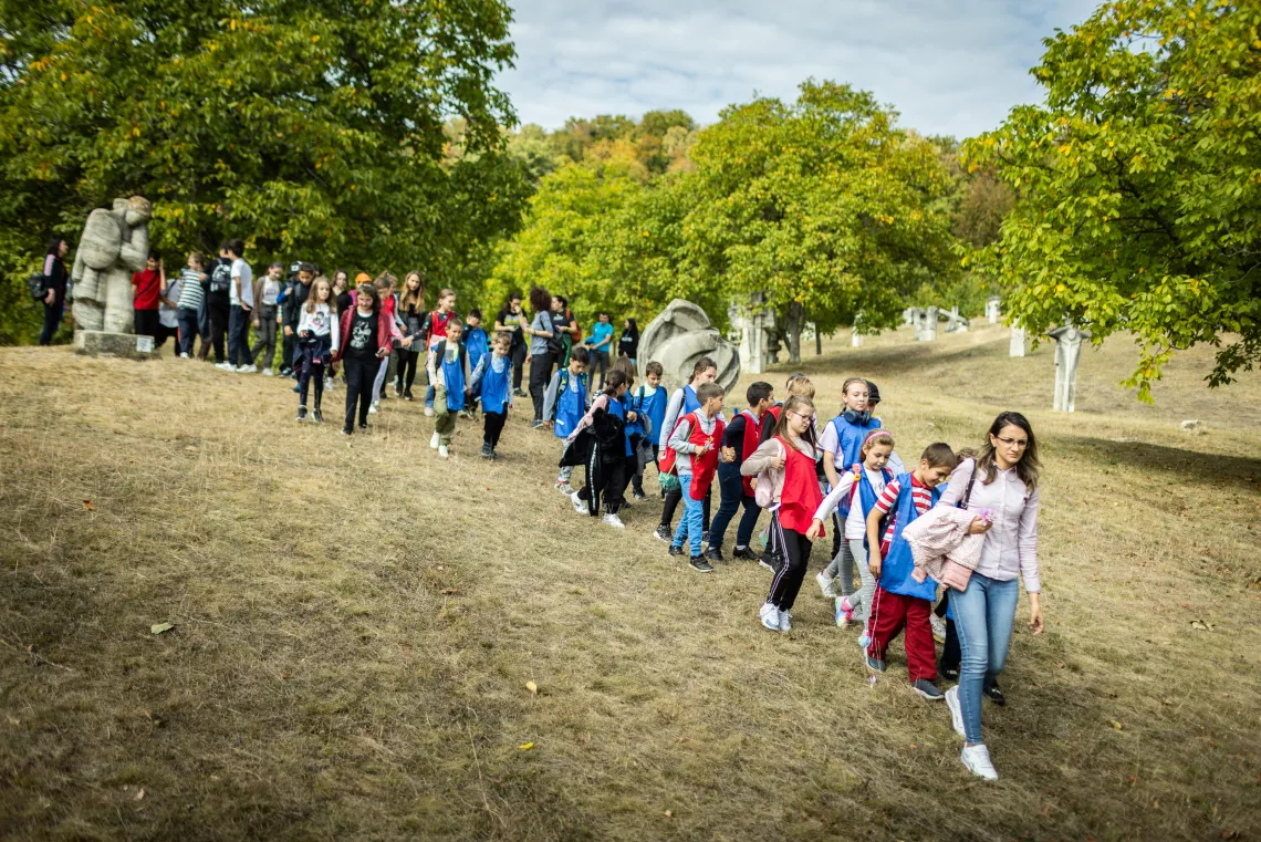Children line up leaving a sculpture camp area