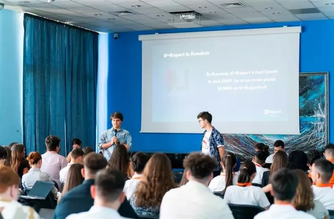 Poză cu doi copii care prezintă mecanismul U-Report.