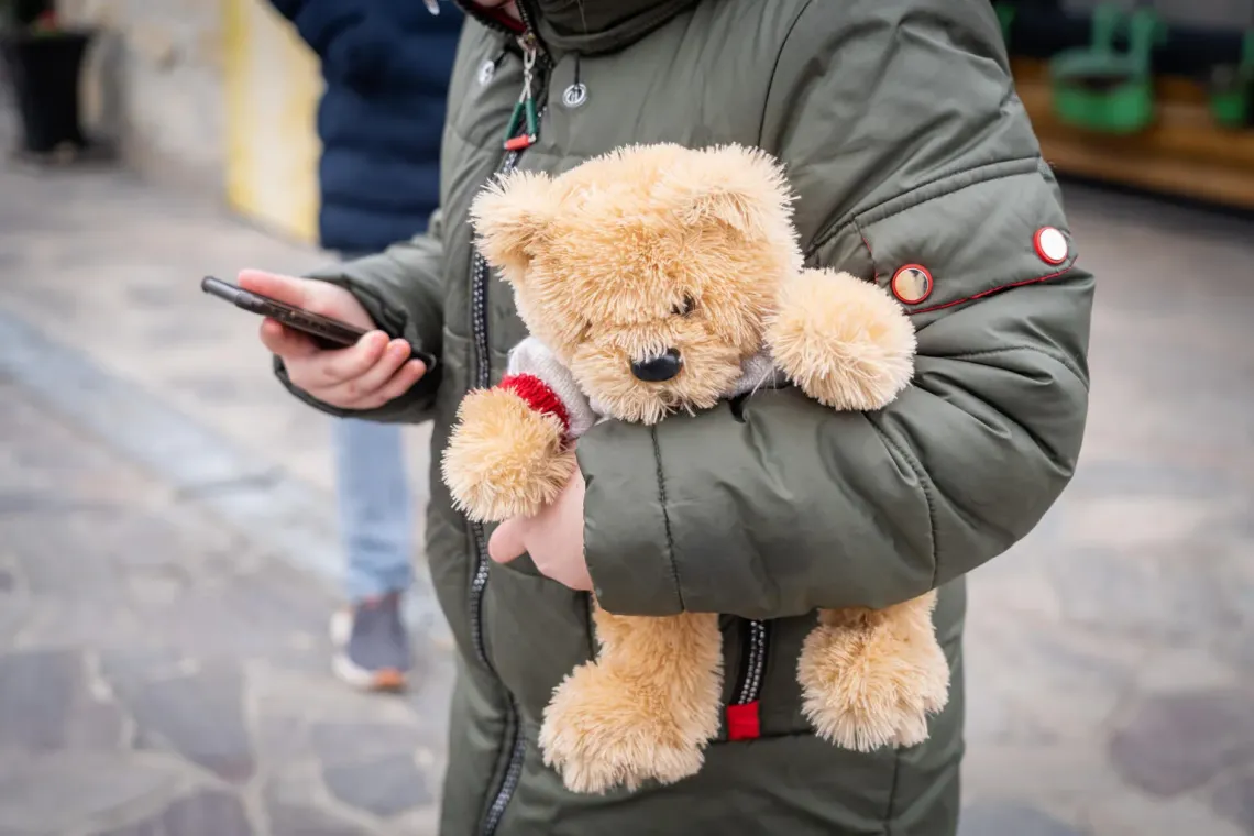 a child who holds a stuffed toy