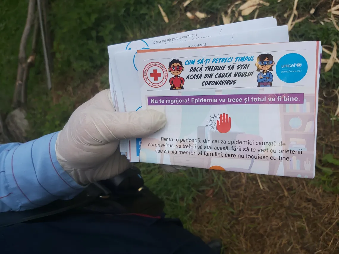 Dirigintele Marian Cioacă țin&acirc;nd &icirc;n m&acirc;nă pliante UNICEF cu informații esențiale despre igiena corectă și prevenția COVID &ndash; 19 și idei de activități de făcut &icirc;n timpul izolării &icirc;n Moeciu de Jos, &icirc;n centrul Rom&acirc;niei, &icirc;n data de 5 mai, 2020.