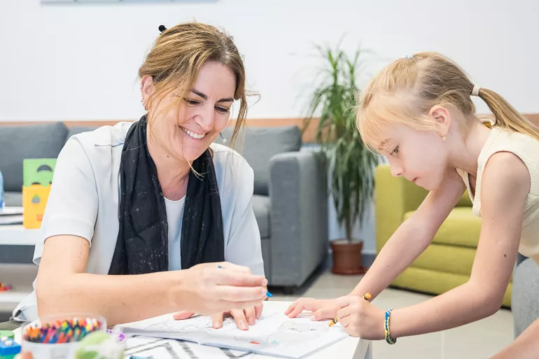 Anna Riatti, UNICEF Representative in Romania, playing with a Ukrainian child