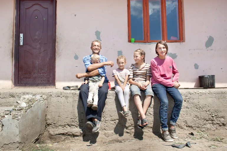Father with children in front of the house, Romania