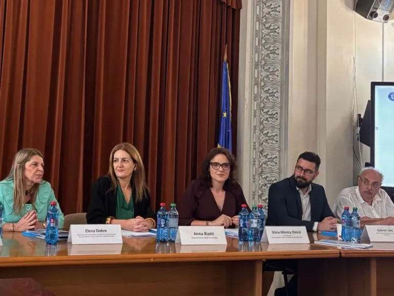 A panel of five people being photographed.
