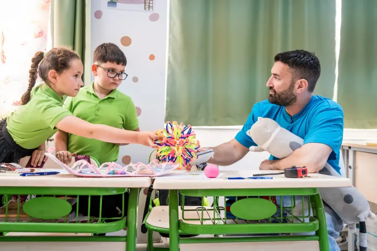 A child gives a toy to Smiley, UNICEF National Ambassador