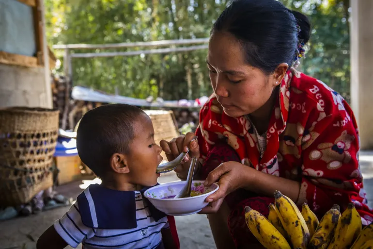 A mother feeds her child