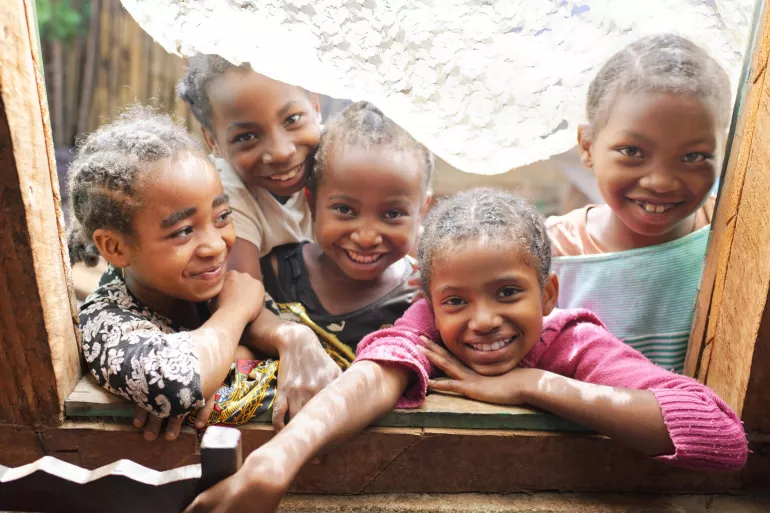 Group of children standing in a window frame