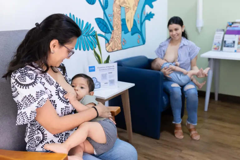 Two mothers breastfeed their children