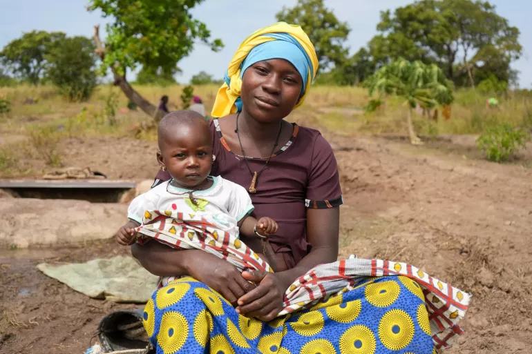 A mother holds her child outside