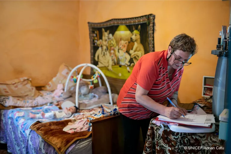 A social assistant is writing her observations after examining a newborn in Corbasca, Bacău county, Romania.