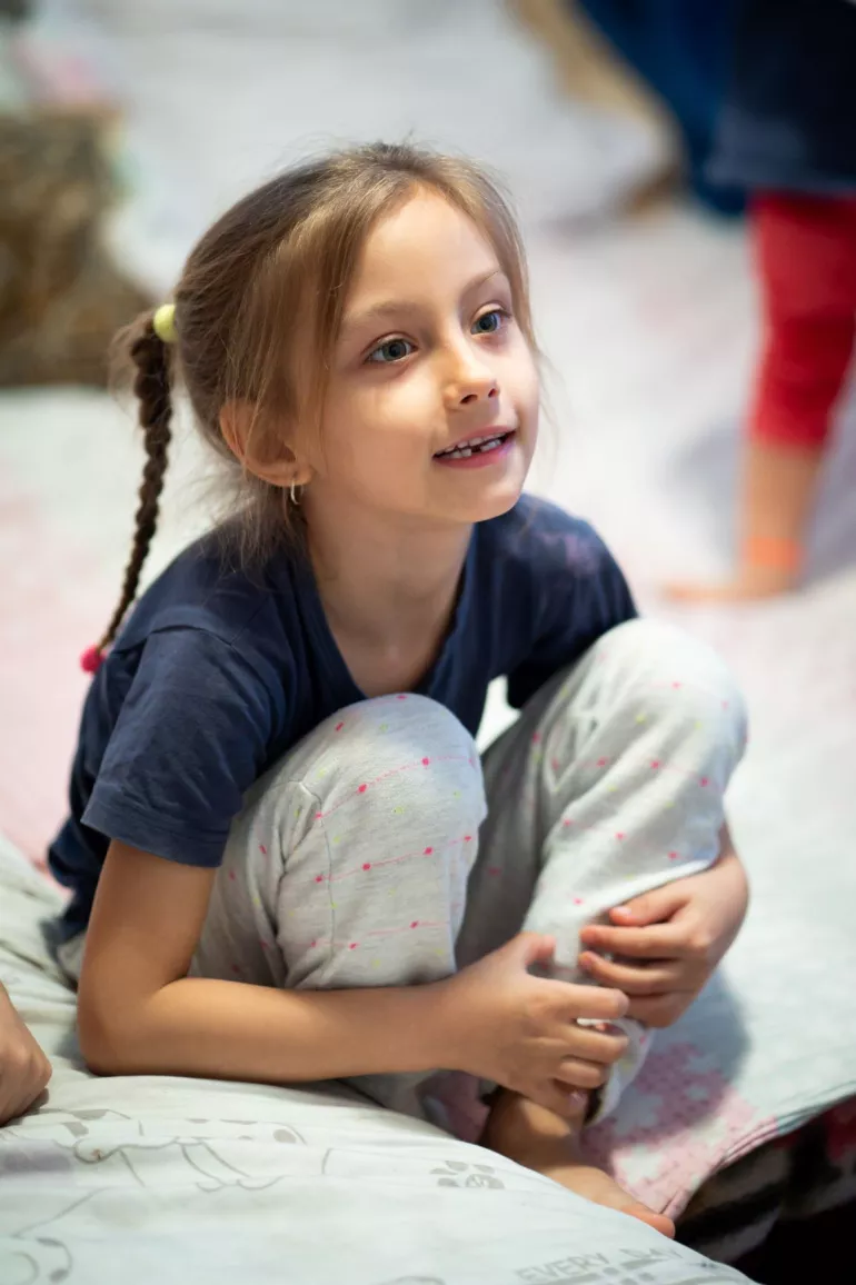 A young girl from Bacau sits on her bed