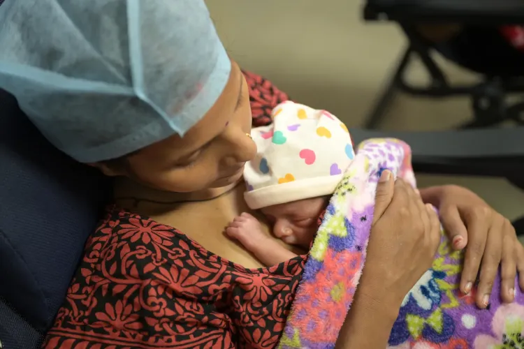 A new mother holds her premature born baby to her chest to provide Kangaroo Mother Care.