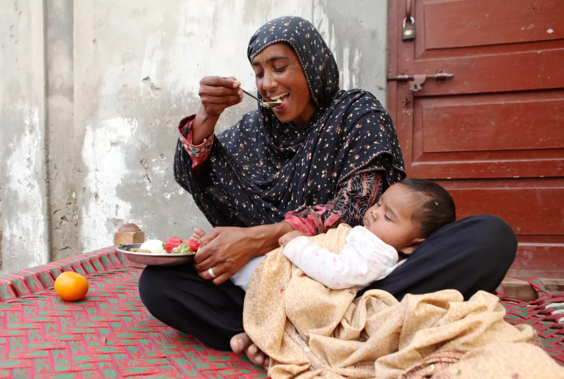 At local health house a lactating woman eats nutritious food.