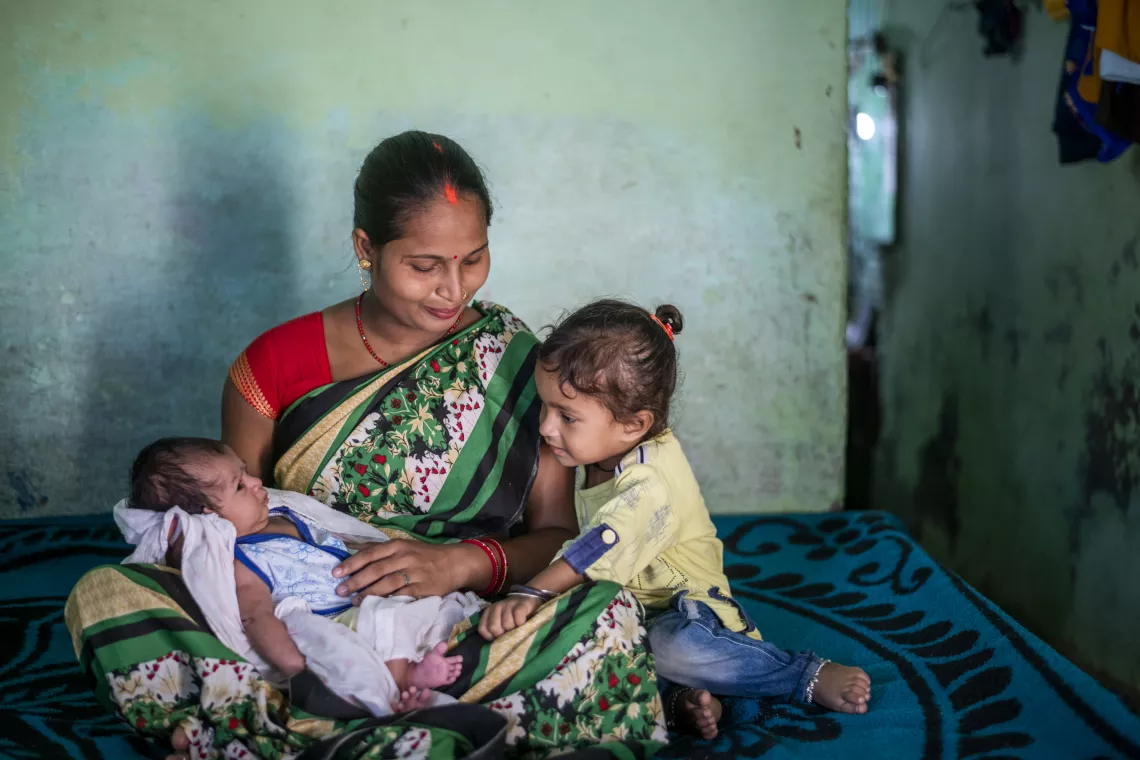 25 years old Priya Devi reacts as she interacts with her newborn child at her house in Cholapur in Varanasi, Uttar Pradesh.