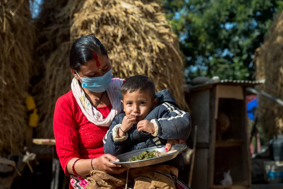 Ishwora Bhandari's son having the green leafy vegetables and bread made of buckwheat at Dipayal Silgadhi-5, Gholtada. 