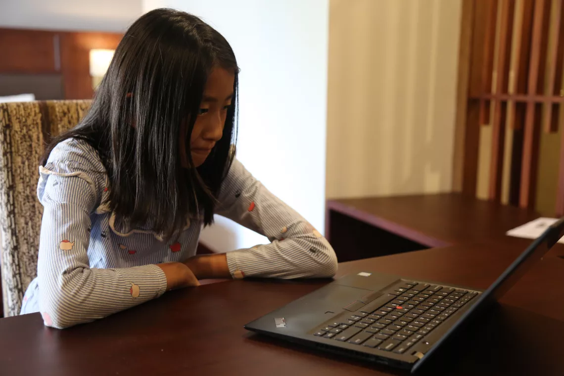 A nine-year-old child, Thenley Tshering Choden,&nbsp;watches a movie and plays on a cell phone at home.