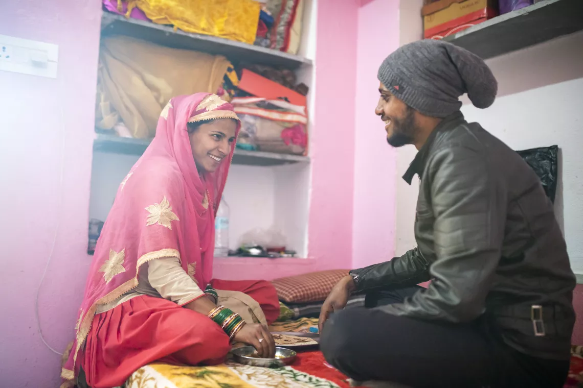 Shaheen, a pregnant woman, sits with her husband Altaf