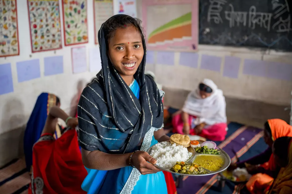 A woman holds a plate of food