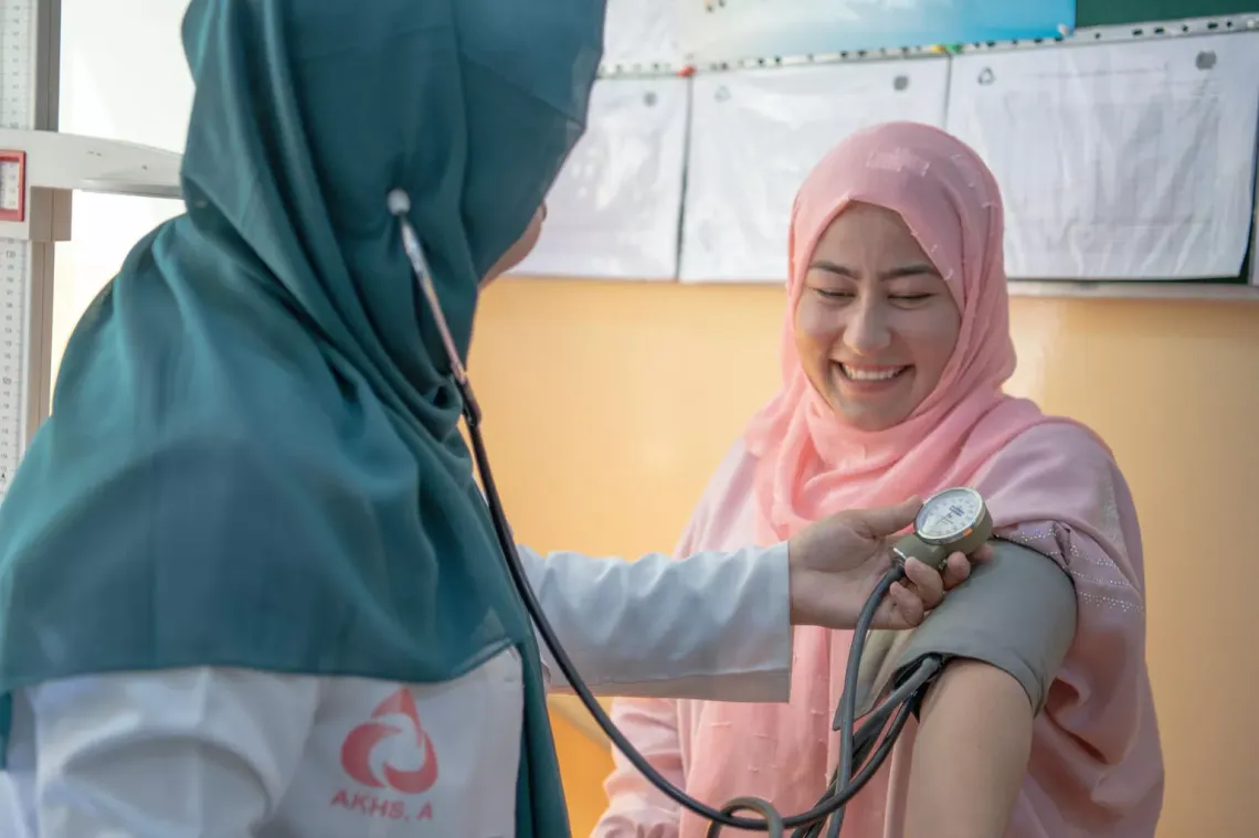 A woman visits a health clinic and has her blood pressure checked