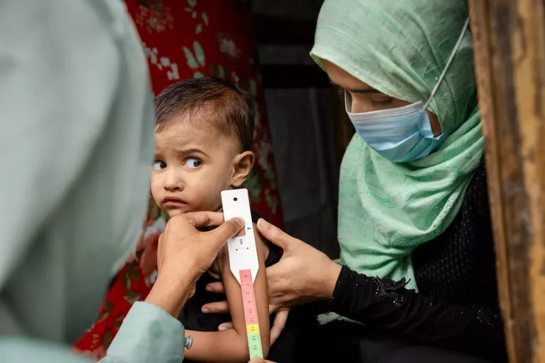 Community nutrition volunteer Noor, 28, to provide nutrition counselling and assess the nutritional status of her daughter Jishan, 2.