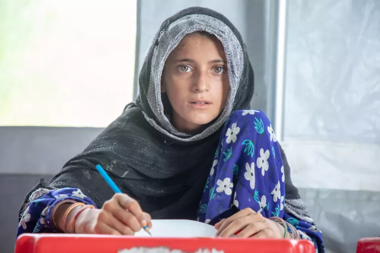 12-year-old Gulsum colours on paper inside a UNICEF-supported child-friendly space.