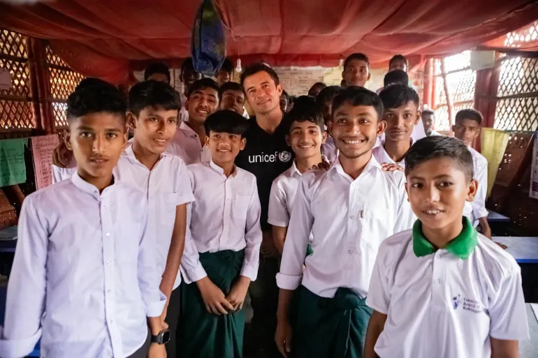 Orlando Bloom posing with students of Grade 9 inside their classroom in Camp 9, Cox's Bazar.