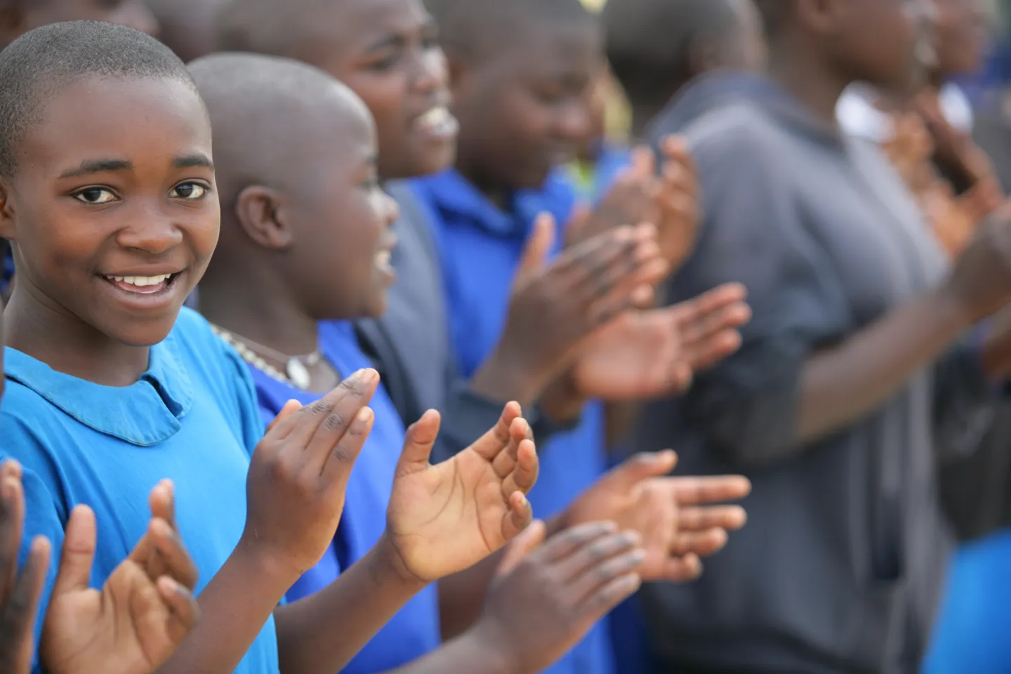 Students stand in a line clapping