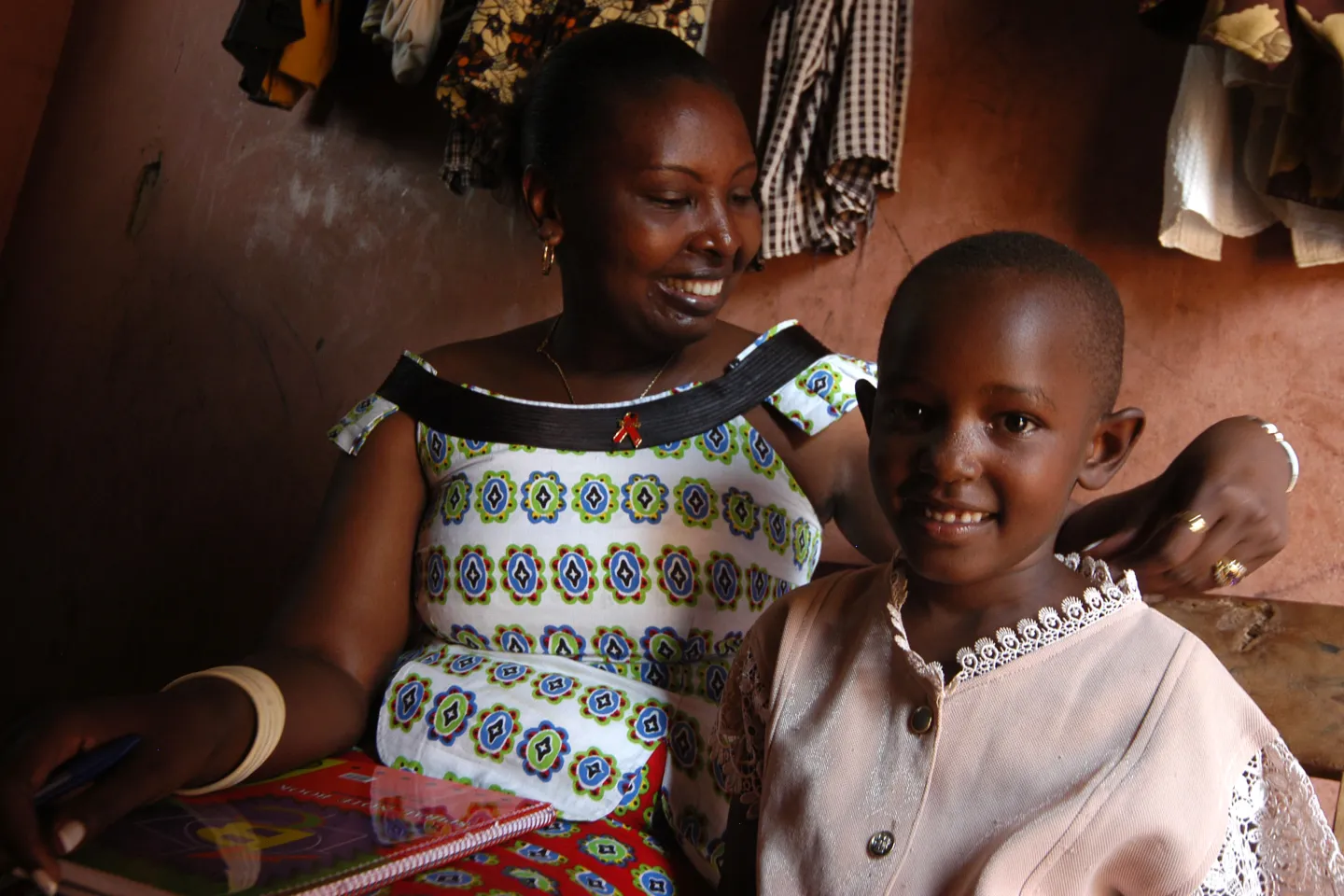 A mother in Rwanda looks lovingly at her young daughter in their rural home