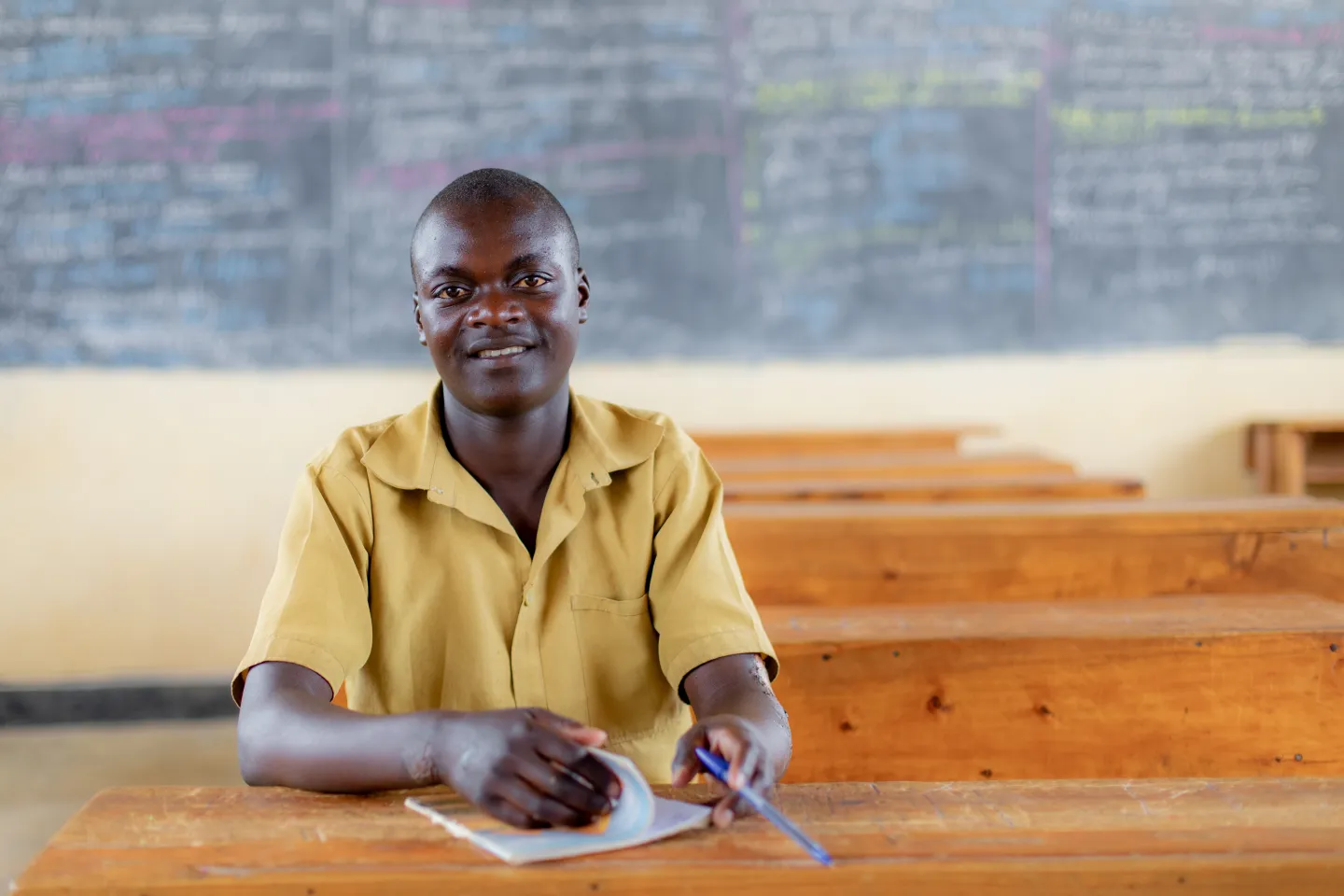 Marcel, 16, smiles inside his classroom in Rwanda. After dropping out two years ago, Marcel has returned to school to become top of his class and will graduate from primary school this year.