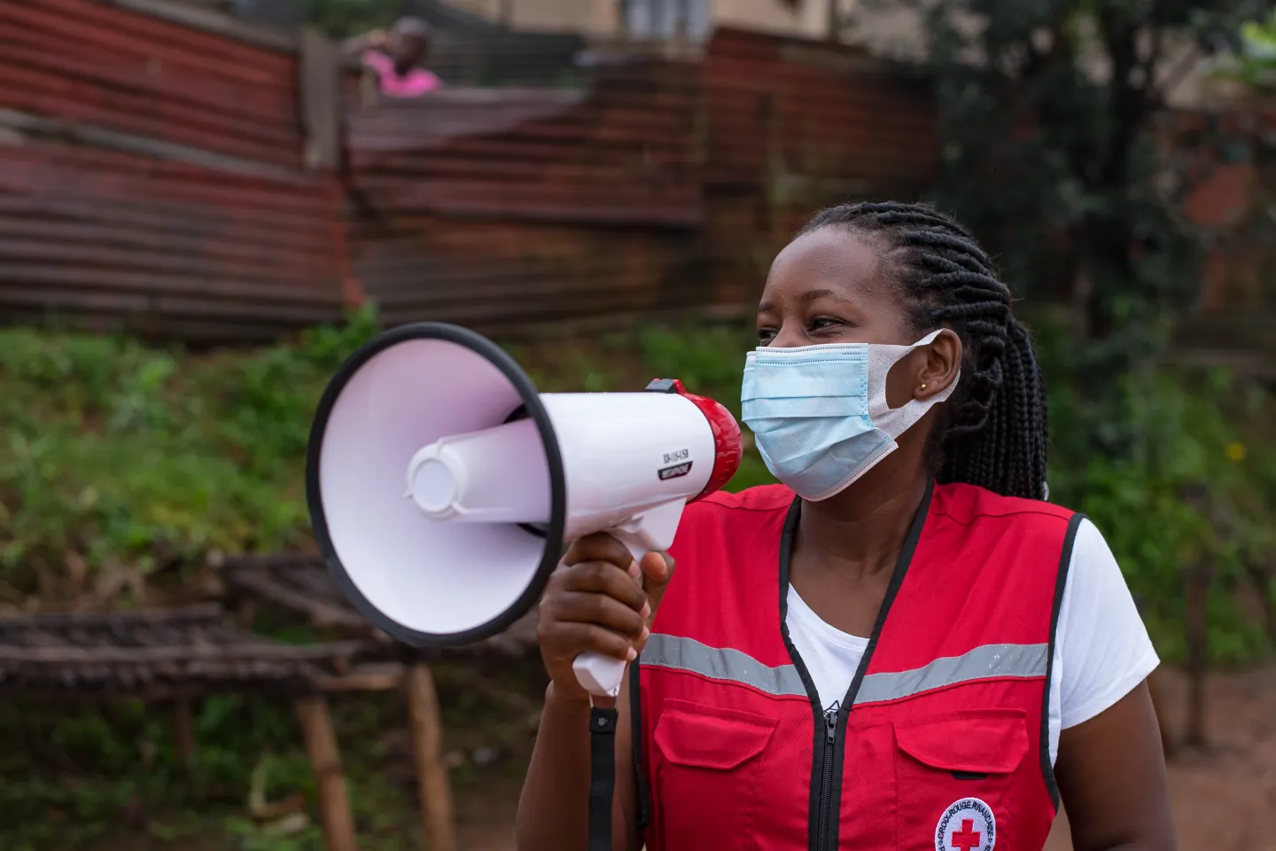 Justine explains how to practice social distancing to Josiane, a street vendor at a Gatsata market. 