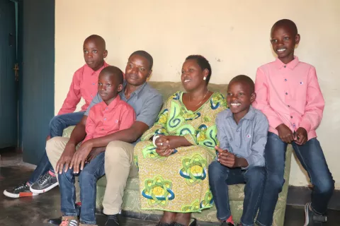 Manzi smiles with his new brothers and parents. Thanks to UNICEF-supported social workers, Manzi found a loving family and was able to move out of his orphanage.