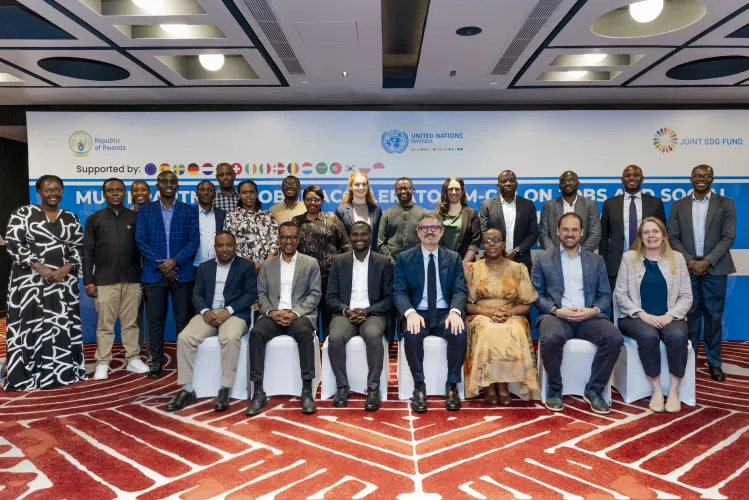 A group photo with some people standing and others seated in front of them.