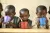 Three children at a UNICEF supported early childhood development centre sip porridge for breakfast.