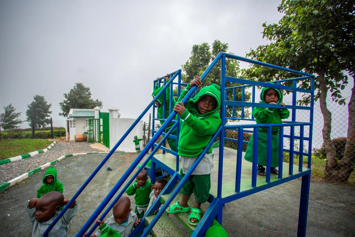 Children play outside at their day care centre while their parents harvest tea on the plantation.