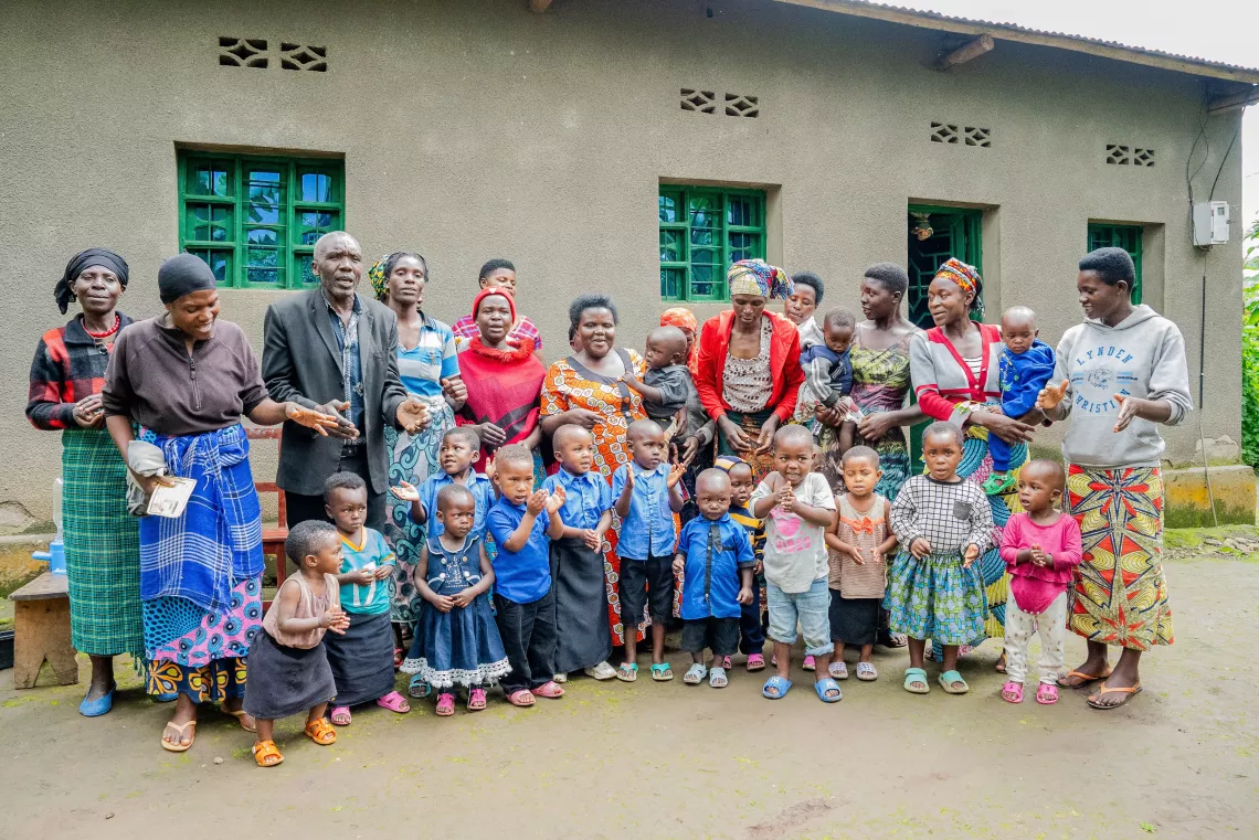 A group of adults and small children gather for a picture.