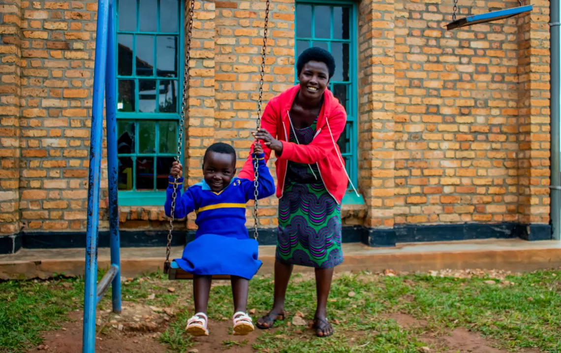Olive Dukundimana pushes her daughter Ikaze on the swings at the UNICEF-supported Gikomero Early Childhood Development Centre in Rwanda. 