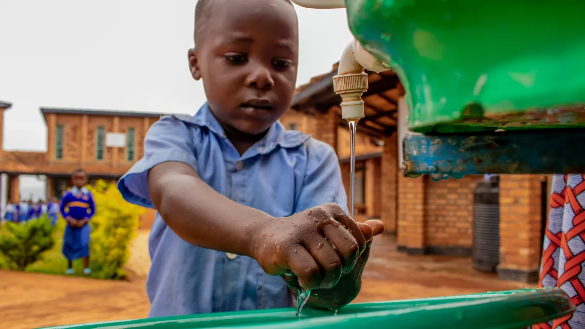 A child at a UNICEF supported early childhood development centre in Rwanda washes her hands with soap.