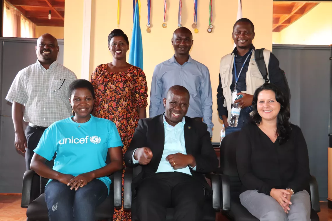 Rwandan social worker Cyriaque (back row, second from right wearing blue) with UNICEF Rwanda staff. Cyriaque was one of the social workers responsible for finding Manzi a family.