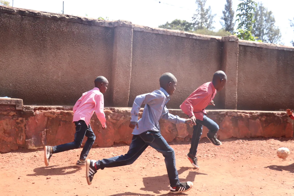 Manzi plays football with his new brothers. With support from UNICEF, dedicated Rwandan social workers were able to place Manzi with a family and move him out of his orphanage.
