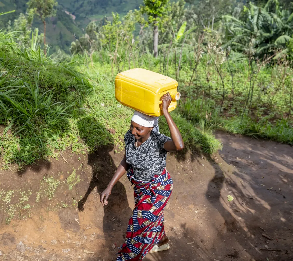 a woman carrying a jerrycan 