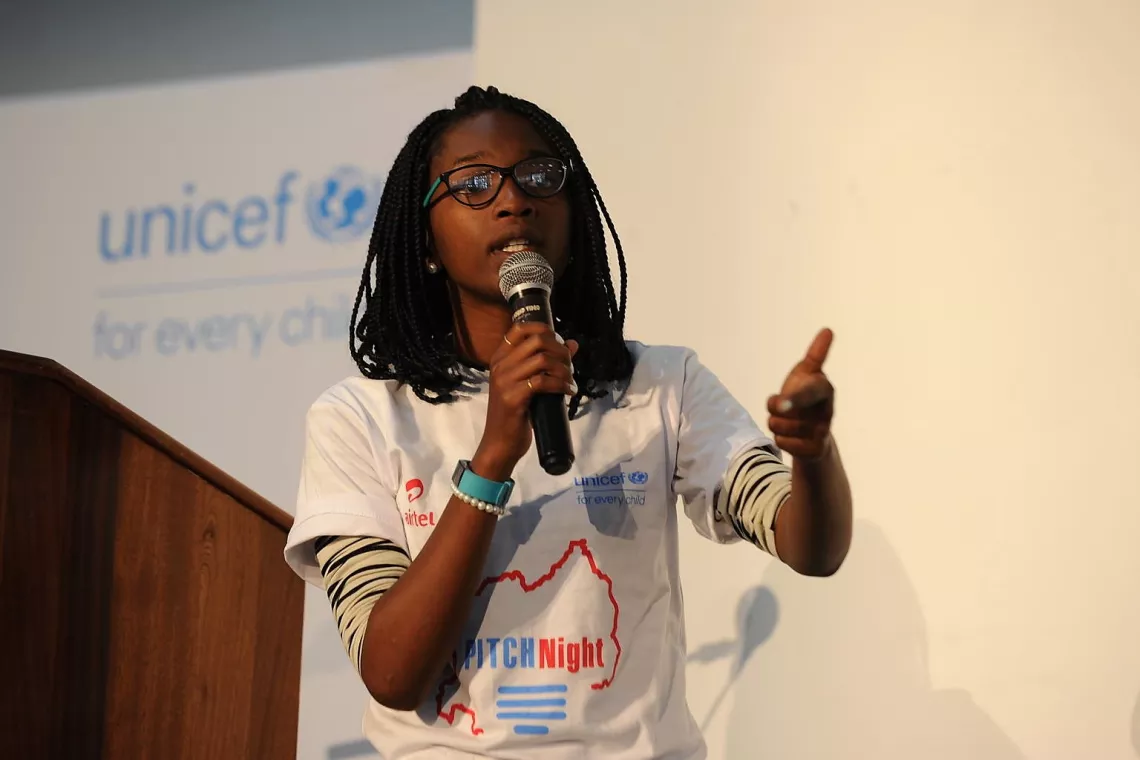 Girl teenager in Rwanda stands on stage pitching business idea