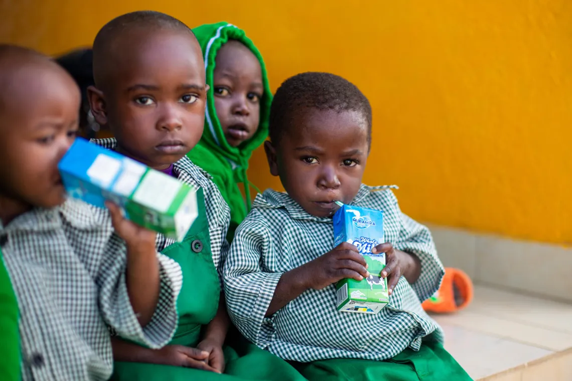David sips his milk box during the morning break at his day care centre on the Rutsiro Tea Plantation.