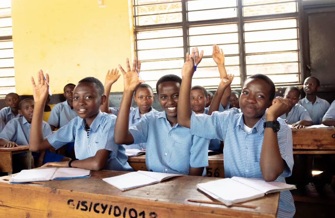 students in class raising hands