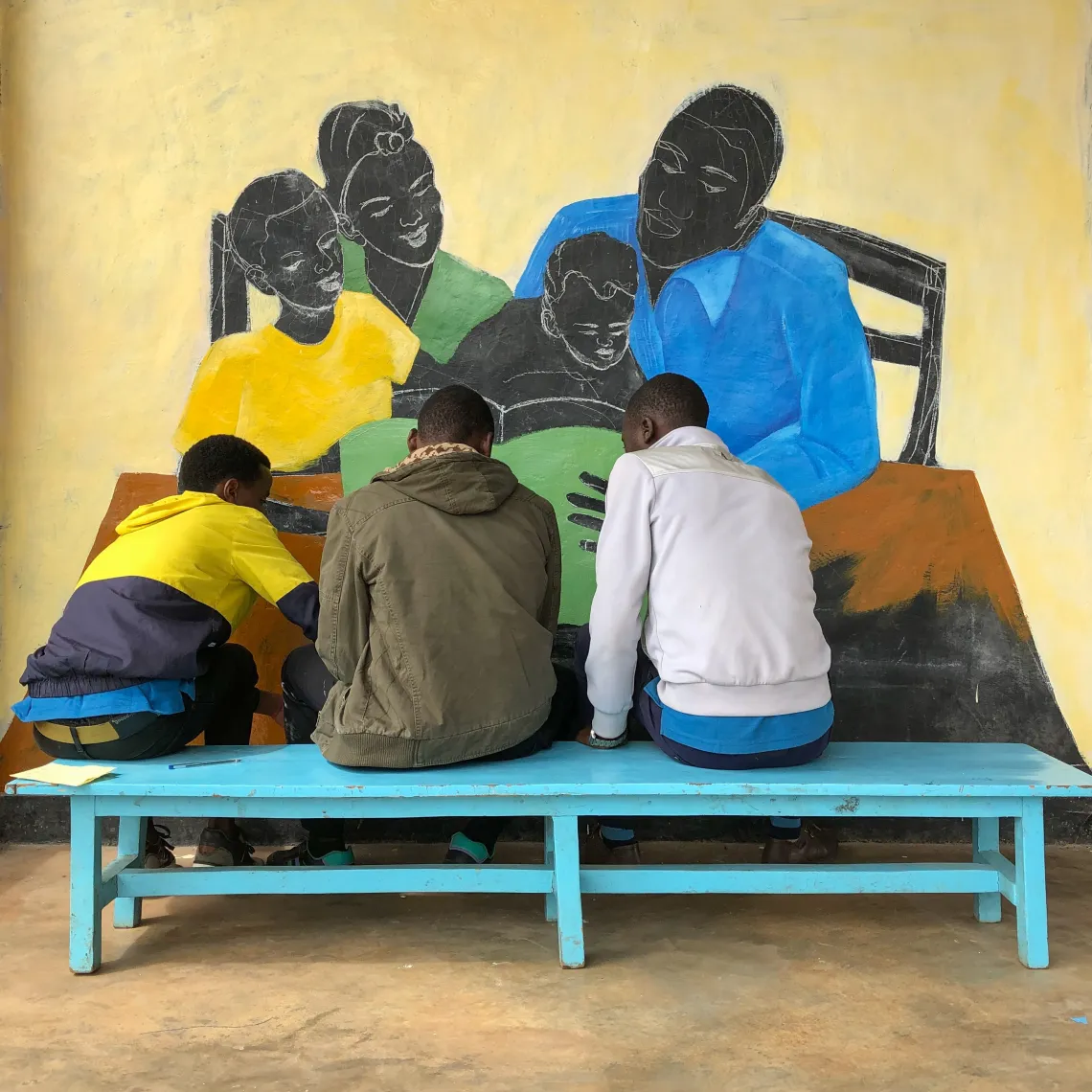 Caregivers in Nyabihu District help paint their new mural at the Bigogwe Early Childhood Development Centre.